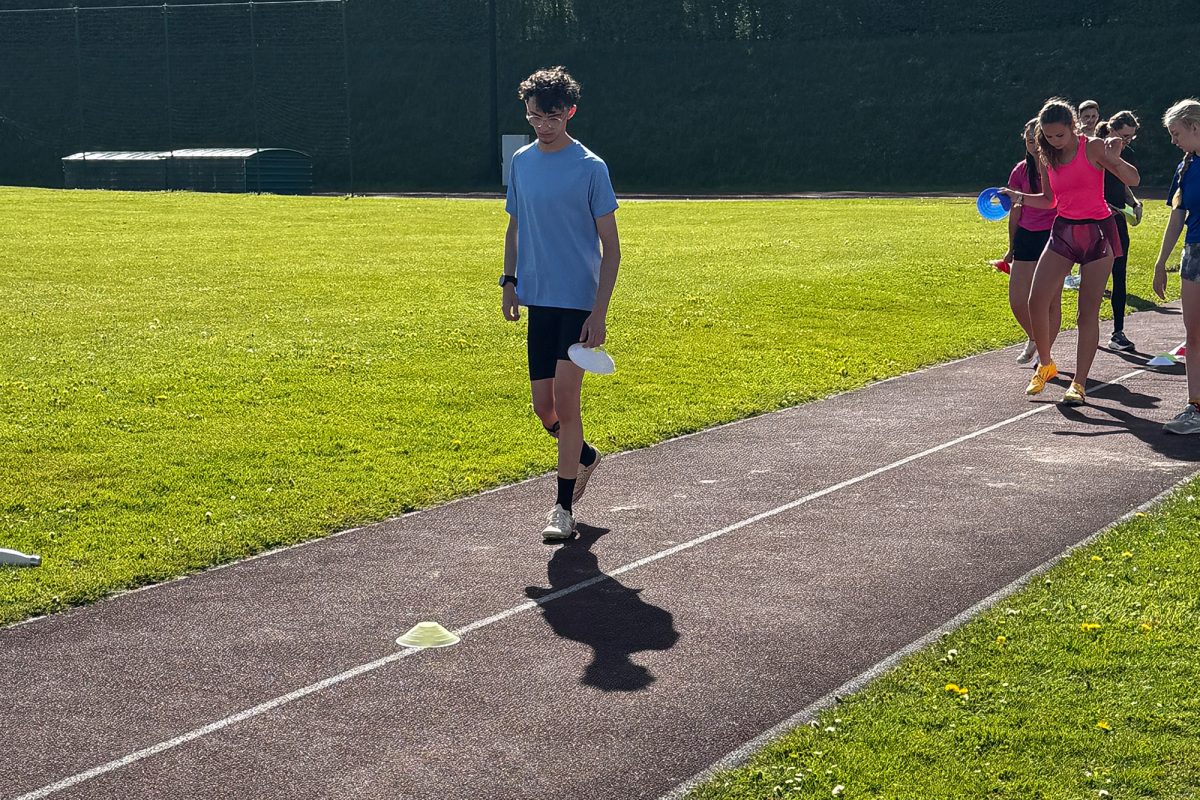 Junge Athleten laufen auf der Aschebahn