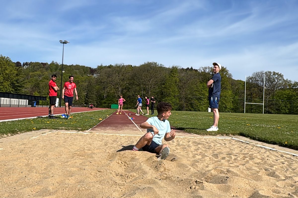 Sportler beim Sprung in die Sandgrube