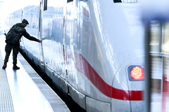 ICE-Zug der Deutschen Bahn an einem Bahnsteig, ein Mann öffnet die Tür