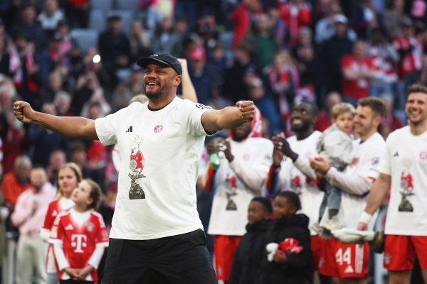 Vincent Kompany feiert mit emporgestreckten Armen den Sieg in der Bundesliga - im Hintergrund mehrere lachende Bayern-Spieler