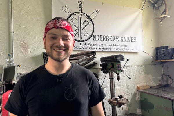 Messermacher Joé Onderbeke mit rotem Kopftuch vor der Standbohrmaschine in seiner Werkstatt