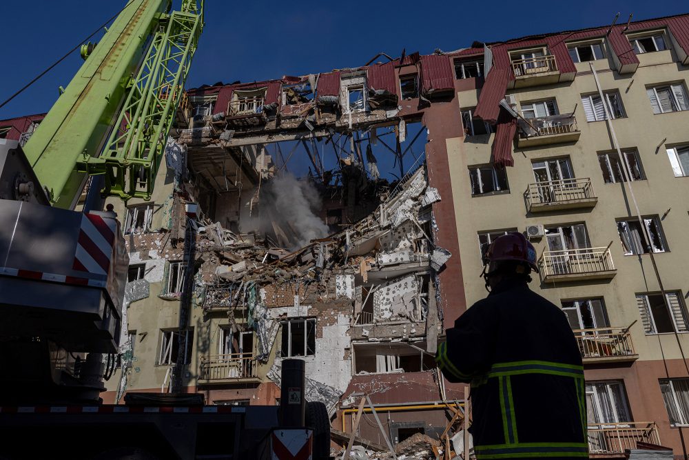 Rettungskraft vor einem schwer beschädigten Wohnhaus in Odessa
