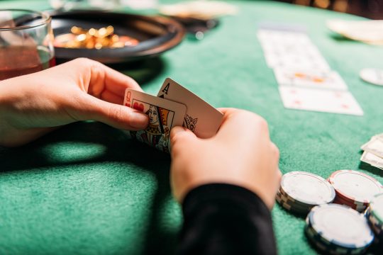 Spieler hält Karten bei einem Pokerturnier in einem Casino