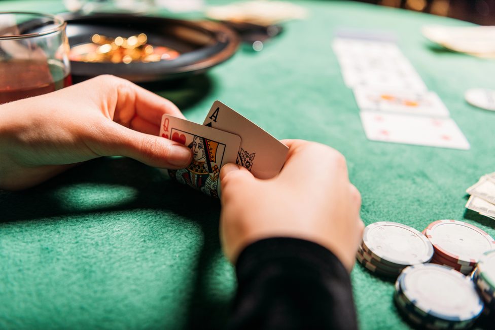 Spieler hält Karten bei einem Pokerturnier in einem Casino