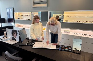 Caroline Pankert beugt sich über einen Katalog und zeigt Thea Cormann darin etwas