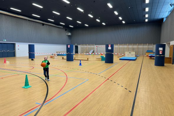 Spielendes Kind mit einem Ball in der neuen Sporthalle in Büllingen