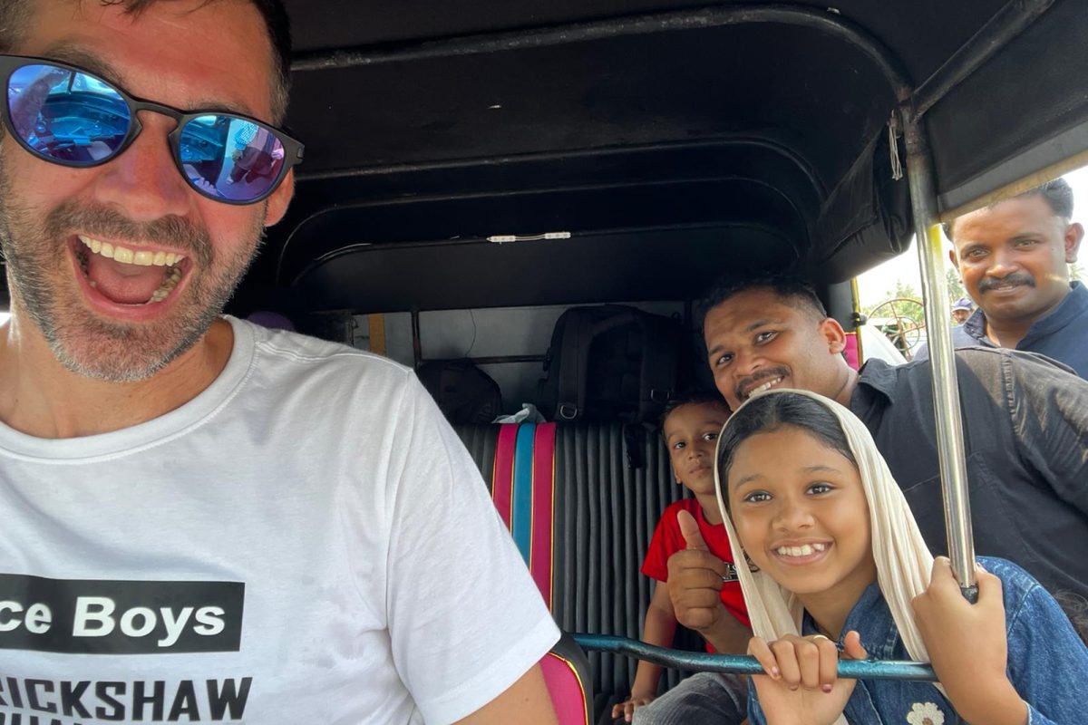 Einheimische schauen ins Tuk-Tuk und lächeln