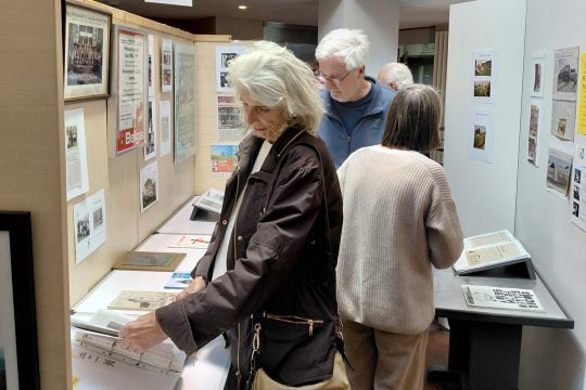 Ausstellungsbesucher schauen sich ausgestellte Dokumente an