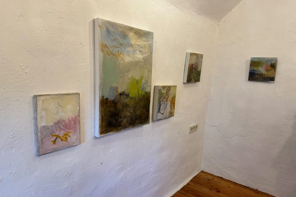 Mehrere Bilder hängen an einer Wand