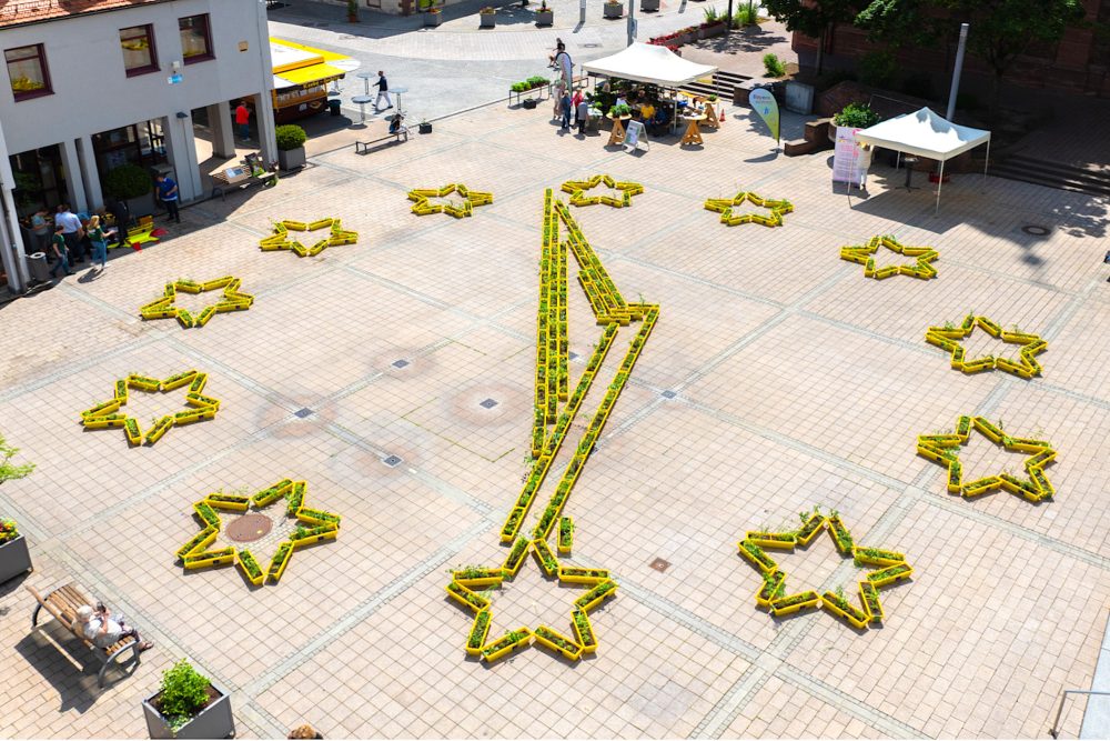 Blumenkästen der Aktion Beedabei auf einem Platz in Alzenau, Deutschland