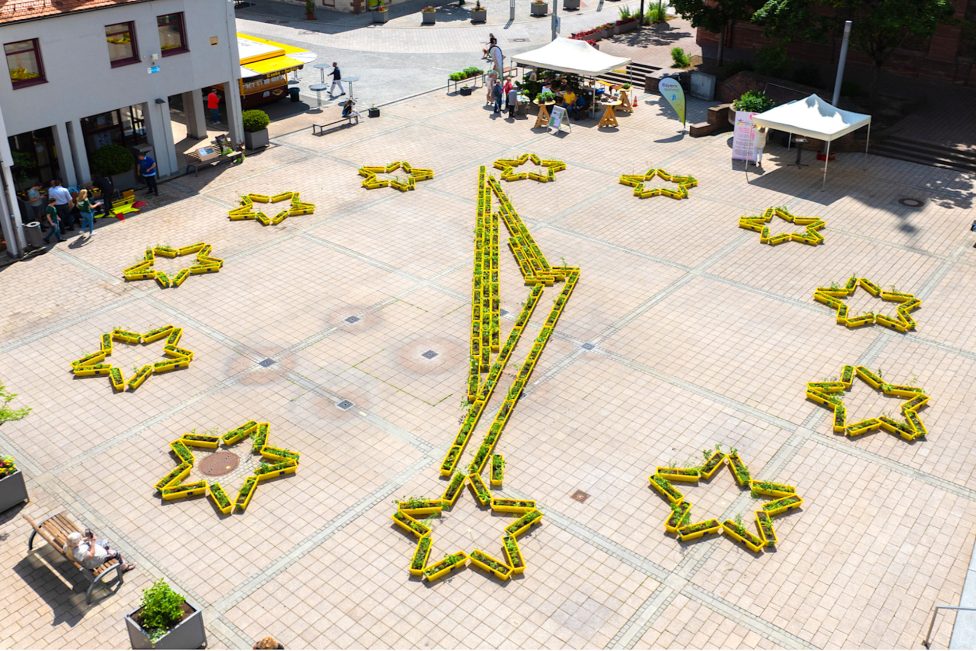 Blumenkästen der Aktion Beedabei auf einem Platz in Alzenau, Deutschland