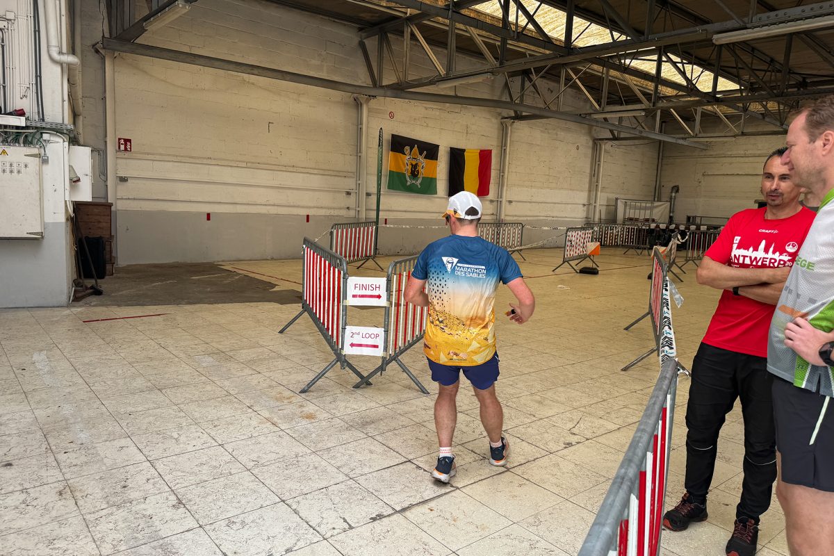 Ein Teilnehmer läuft in die Halle ein und folgt dem Hinweisschild mit der Aufschrift Finish nach rechts