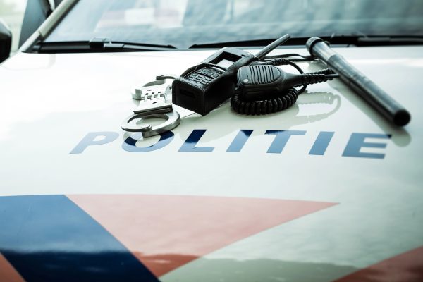 Niederländisches Polizeifahrzeug mit Schlagstock und Handschellen