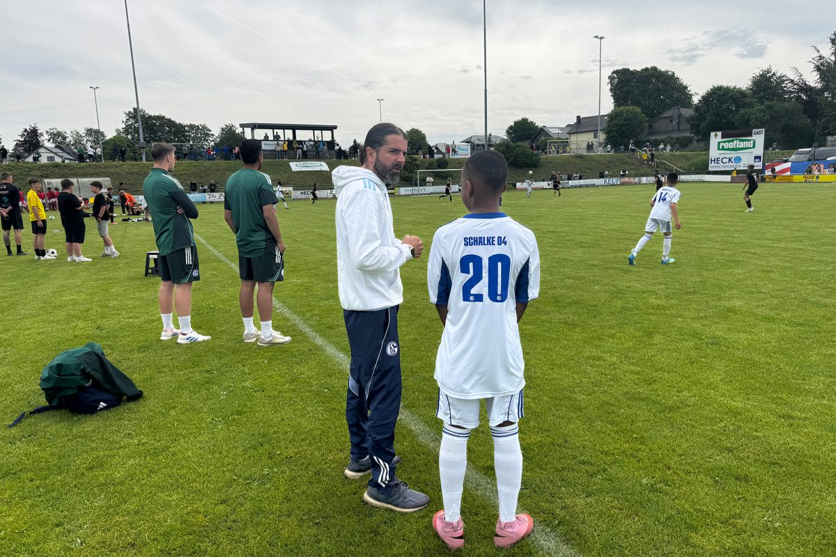 Schalke-Nachwuchstrainer Sam Farokhi, neben ihm steht ein junger Spieler von Schalke 04 mit dem Rücken zur Kamera