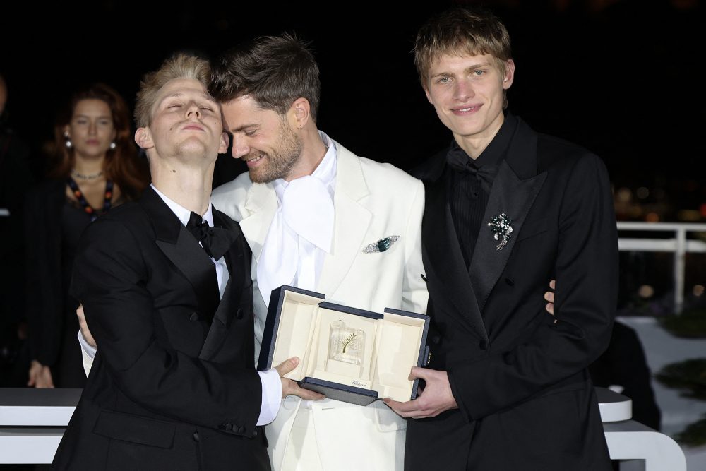 Schauspieler Valentin Campagne, Regisseur Lukas Dhont und Schauspieler Emmanuel Macchia umarmen sich und halten gemeinsam die Trophäe hoch
