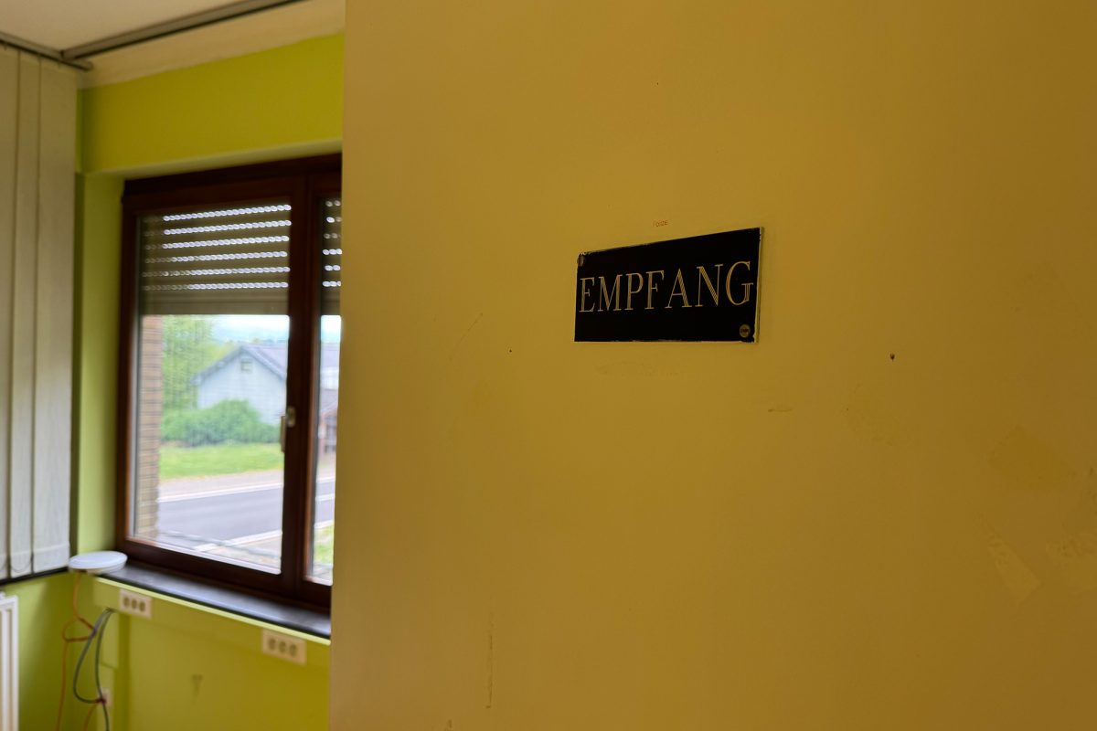 Schild "Empfang" auf gelber Wand