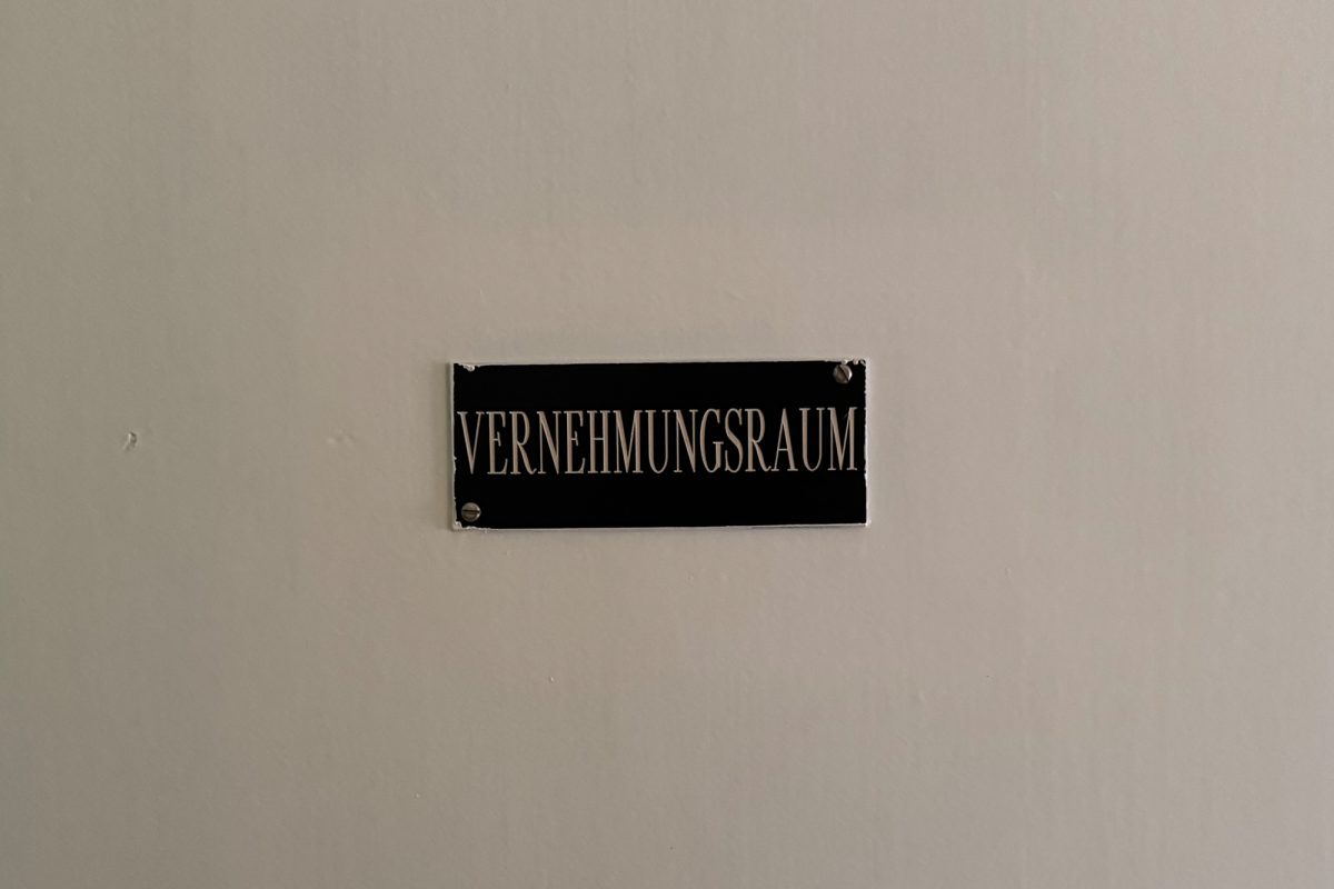 Schild "Vernehmungsraum" an Wand