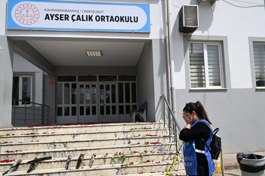 Frau trauert, Blumen liegen auf der Treppe vor der Schule in Kahramanmaras