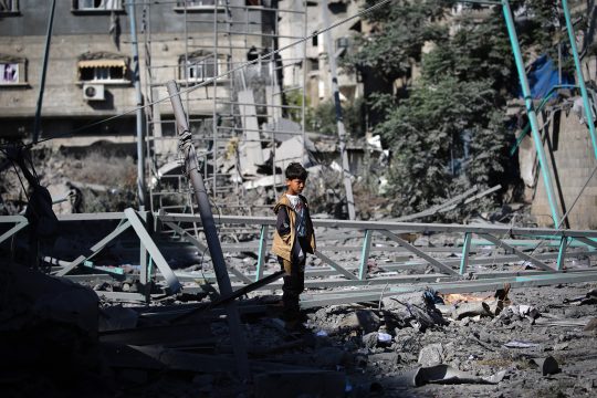 Ein palästinensischer Junge steht inmitten der Trümmer eines Gebäudes, das durch einen israelischen Angriff zerstört wurde