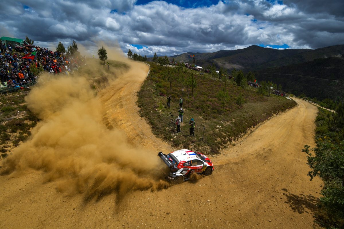 Der Toyota von Sébastien Ogier/Vincent Landais in einer Kurve mit Zuschauern und mächtig Staub