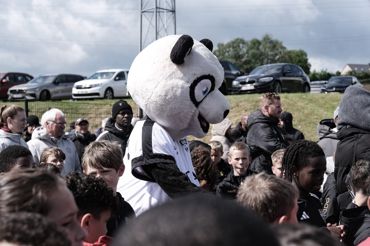 Das Maskottchen der AS Eupen umringt von Kindern
