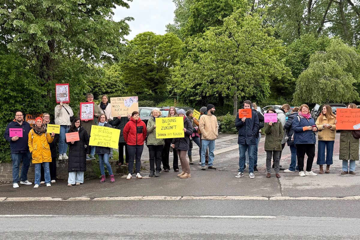 Lehrer der Grundschule Kettenis mit Plakaten am Straßenrand