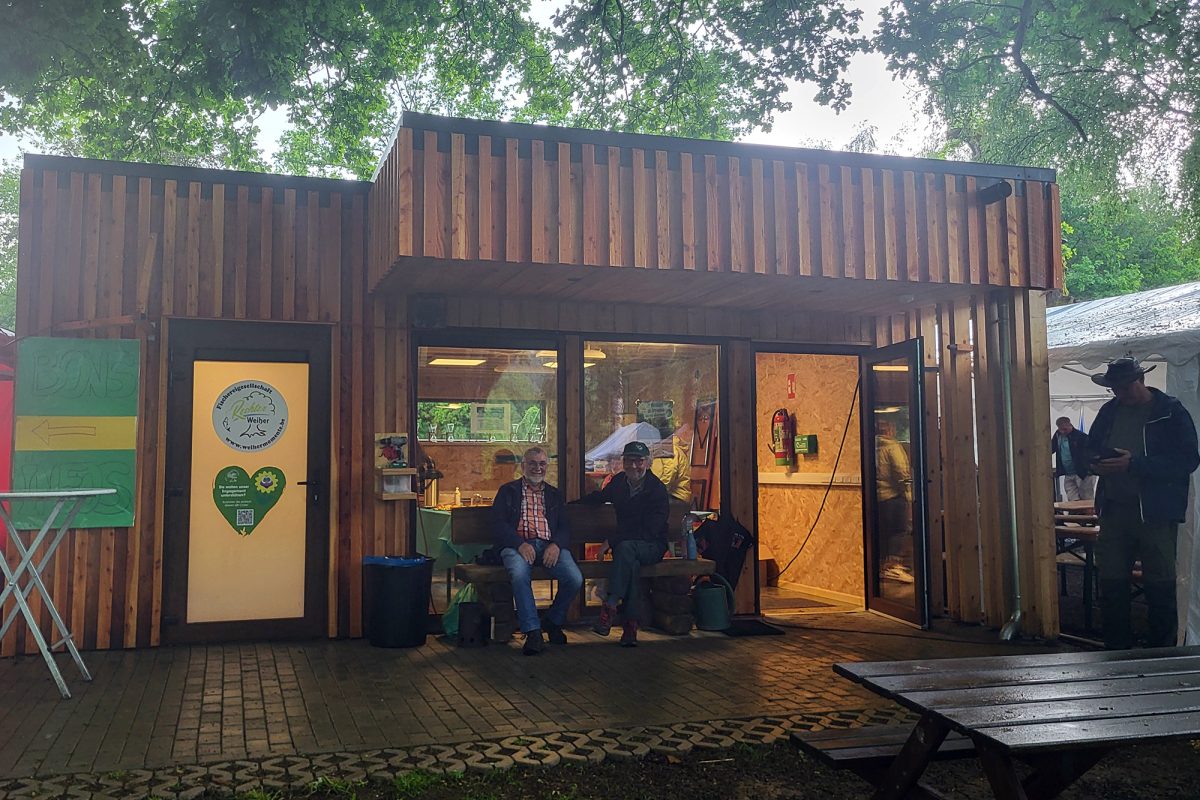 Holzhütte am Rechter Weiher mit mehreren Personen davor