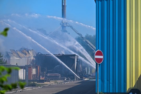 Nach dem Feuer werden die Trümmer des Gebäudes besprüht