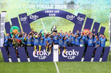 Spieler und Betreuerstab jubeln mit dem Pokal in ihrer Mitte