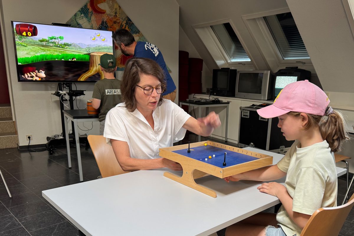 Betreuerin und Kinder spielen im Medienzentrum