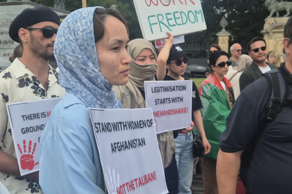 Menschen mit Plakaten protestieren gegen den Aufenthalt einer Taliban-Delegation in Brüssel