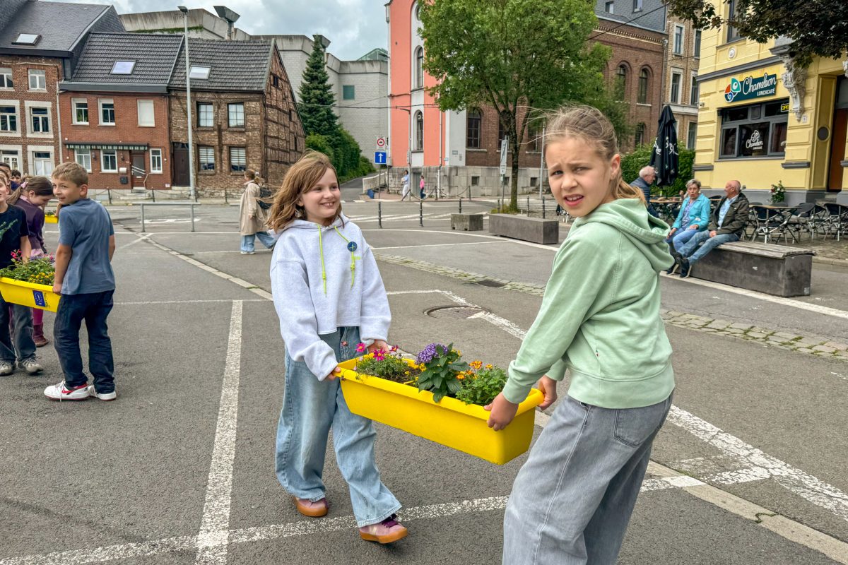 Kinder tragen Blumenkästen