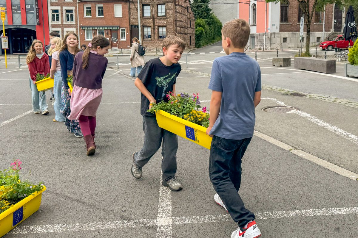 Kinder tragen Blumenkästen