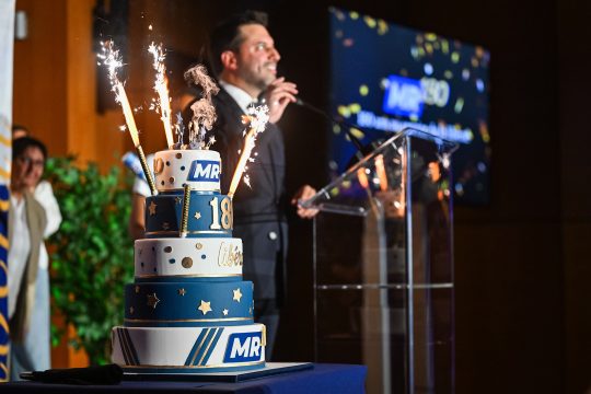 MR-Chef Georges-Louis Bouchez am Rednerpult bei der Jubiläumsveranstaltung am Sonntag in Brüssel - vorne im Bild eine fünfstöckige Torte zum Jubiläum