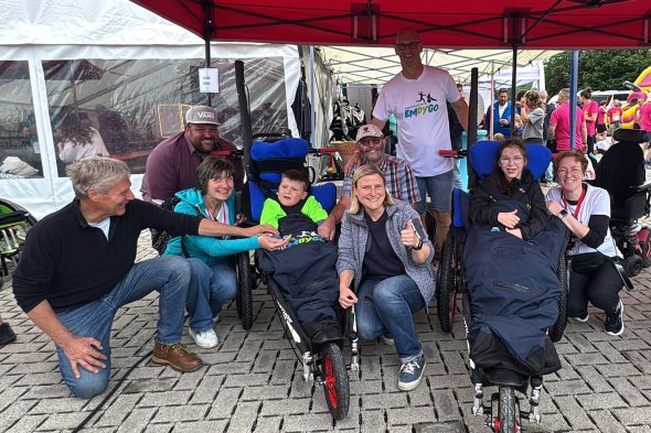 Gruppenfoto mit zwei Kindern im Rollstuhl, ihren Begleitpersonen und Organisatoren von Emdygo