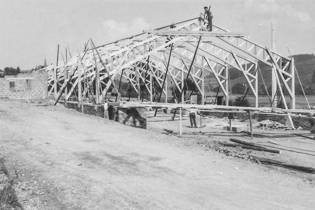Historisches Bild zeigt Arbeiter beim Aufbau des Sägewerks