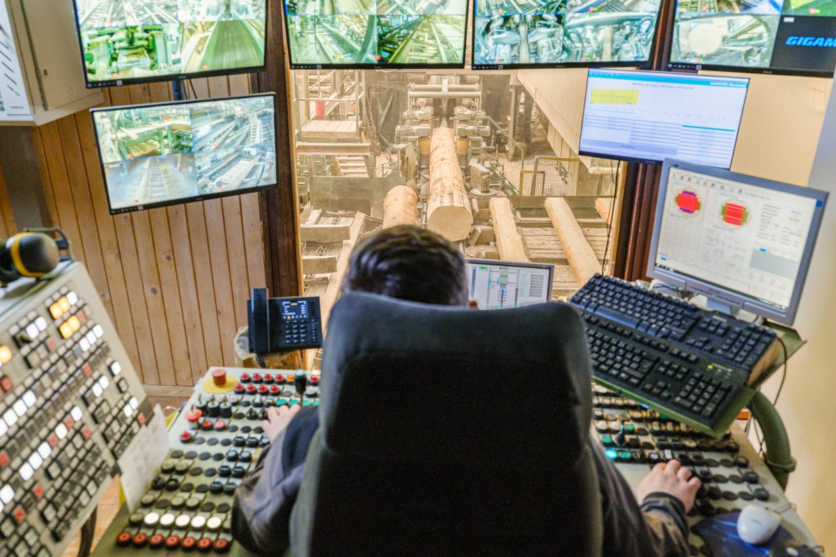 Mitarbeiter von hinten in Kommandozentrale im Sägewerk