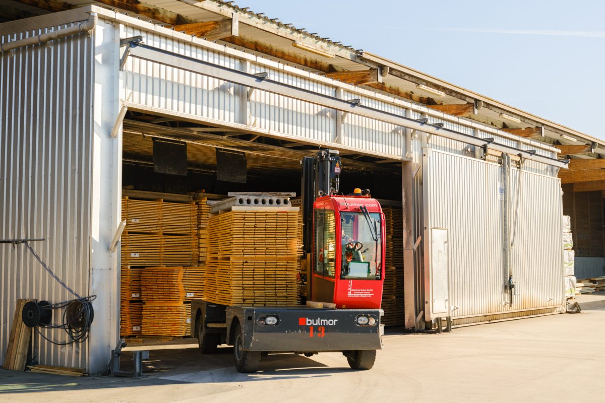 Außenansicht des Holzlagers mit Transportmaschine