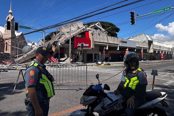 Polizisten vor einem eingestürzten Jollibee-Fastfood-Restaurant in General Santos City