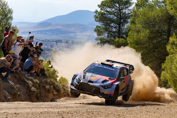 Der Hyundai von Thierry Neuville/Martijn Wydaeghe fährt auf zwei Rädern um eine Kurve, die Zuschauer jubeln