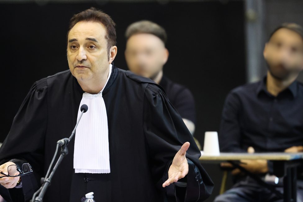 Anwalt Fabrice Guttadauria gestikuliert, im Hintergrund die Angeklagten