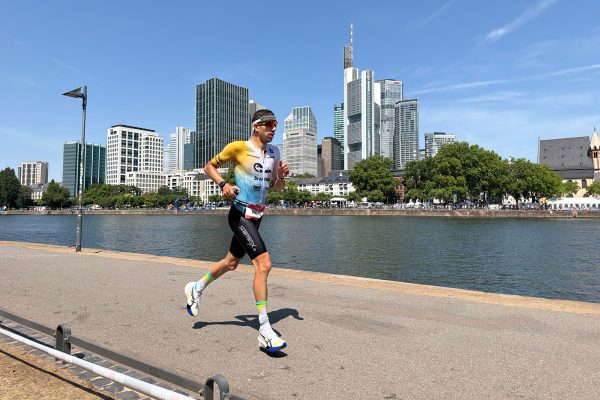 Louis Heukemes läuft am Fluss Main vor der Skyline von Frankfurt