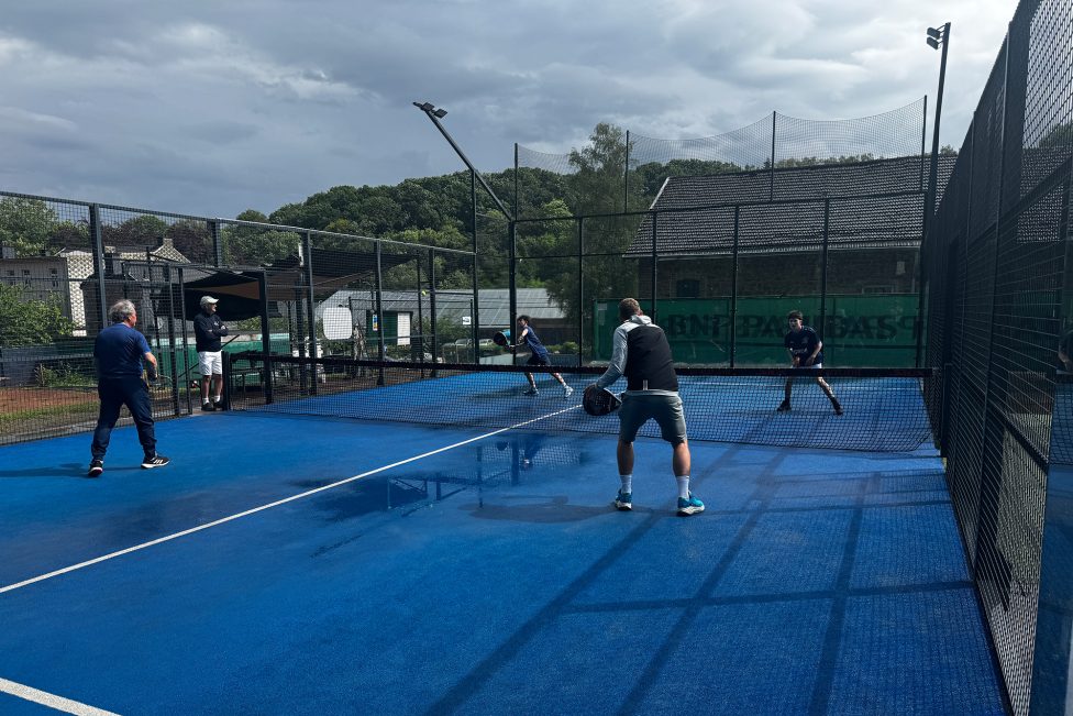 Vier Personen spielen Padel auf einem der Außenplätze