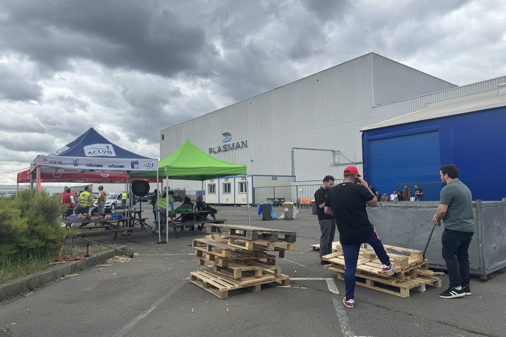 Holzpaletten und streikende Mitarbeiter vor dem Plasman-Werk
