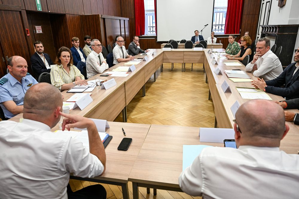 Teilnehmer der Verhandlungsrunde sitzen an Tischen, unter ihnen auch DG-Ministerpräsident Oliver Paasch