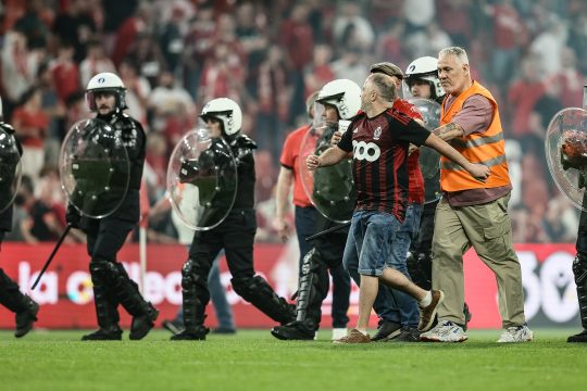 Polizisten treiben Fans vom Platz in Sclessin