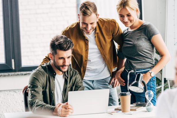 Junge Unternehmer in einem Büro vor einem Laptop