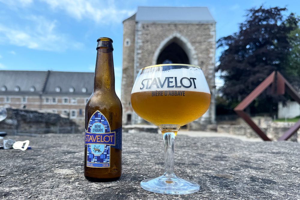 Bierflasche und Bierglas vor der Abtei