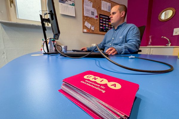 William Vorhagen am Computer, im Vordergrund Visitenkarten von Unia
