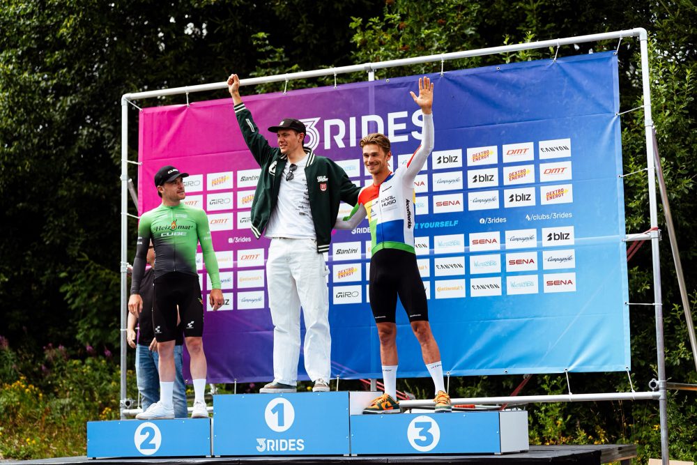 Arne Janssens steht mit zwei weiteren Fahrern auf dem Treppchen